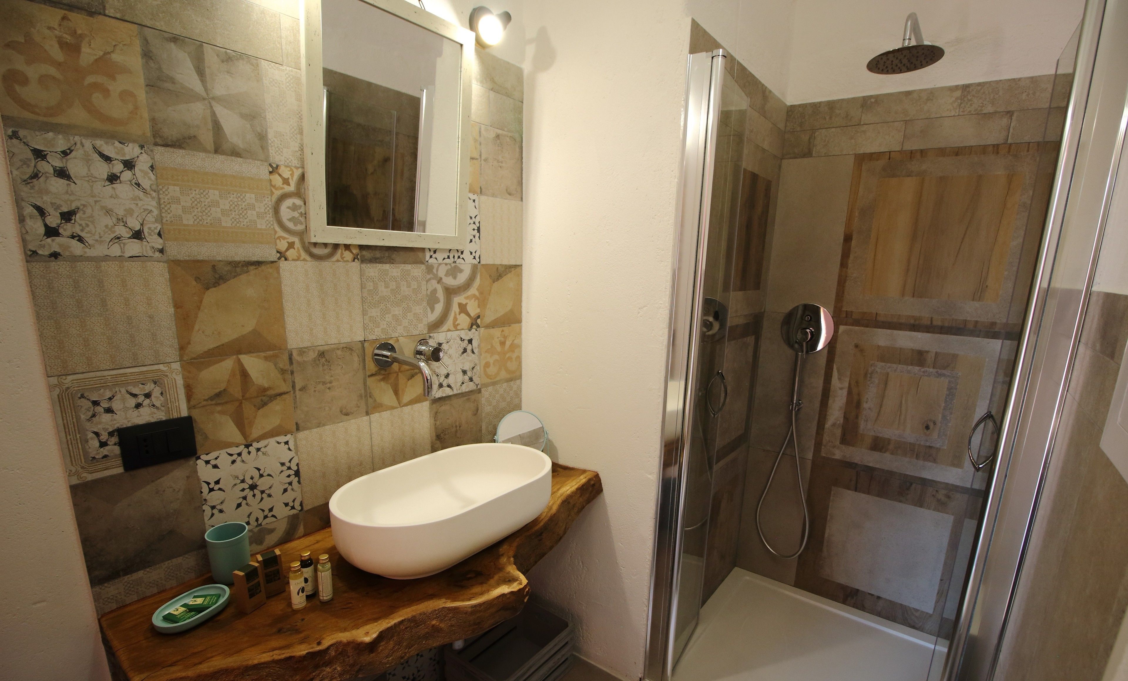Un baño con un lavamanos grande de color blanco, un espejo y una zona de ducha.