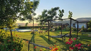 A garden with a pool, sun loungers, and a gazebo. - Agriturimo Essentia Dimora Rurale (Larino)