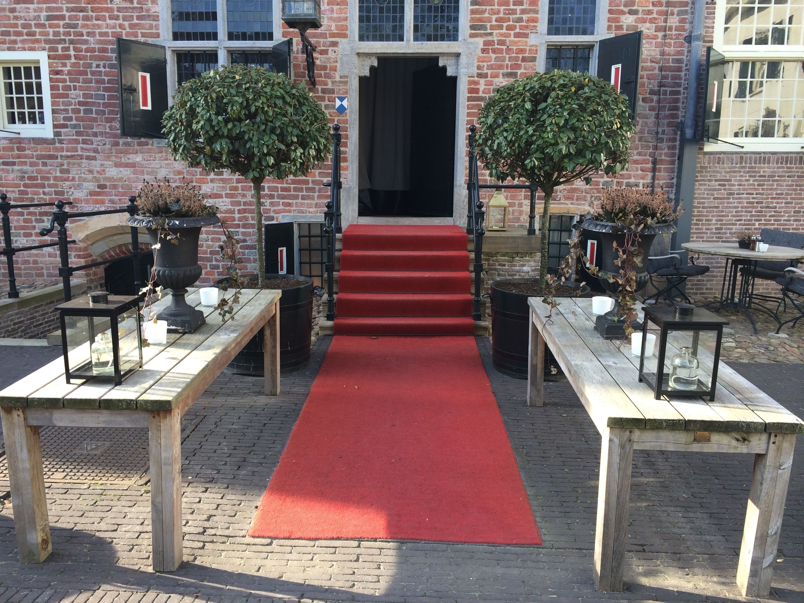 A red carpet leading to a building entrance with brick walls and black-framed windows.