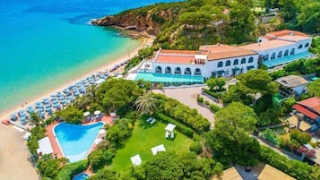 Luftaufnahme eines Hotels an der Küste mit Strand, Schwimmbad und üppiger Bepflanzung.