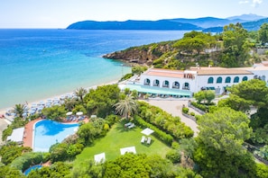 A resort with a swimming pool, beach, and mountain views. - Hotel Antares (Capoliveri)