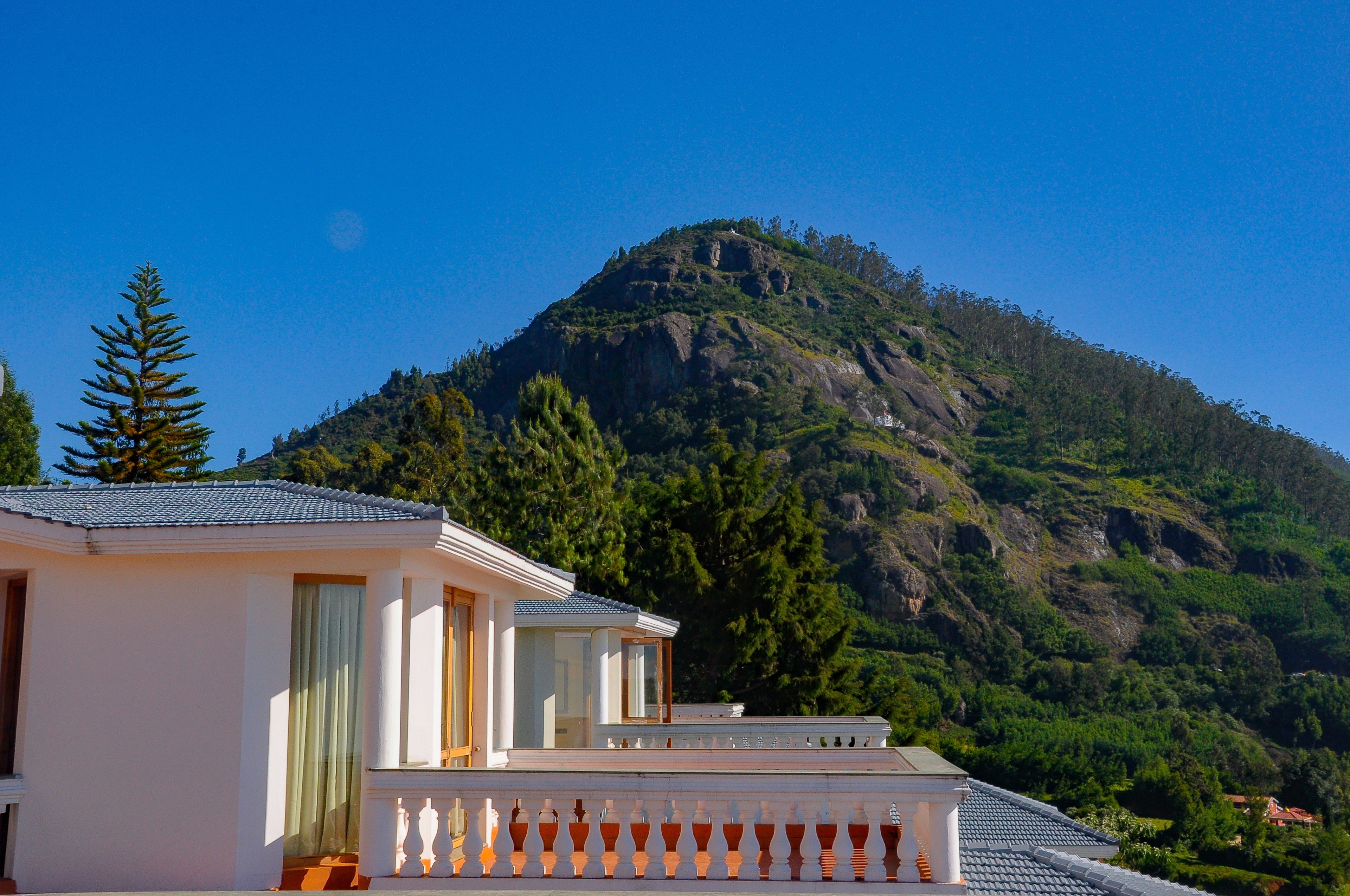 A building with a balcony and a mountain in the background.