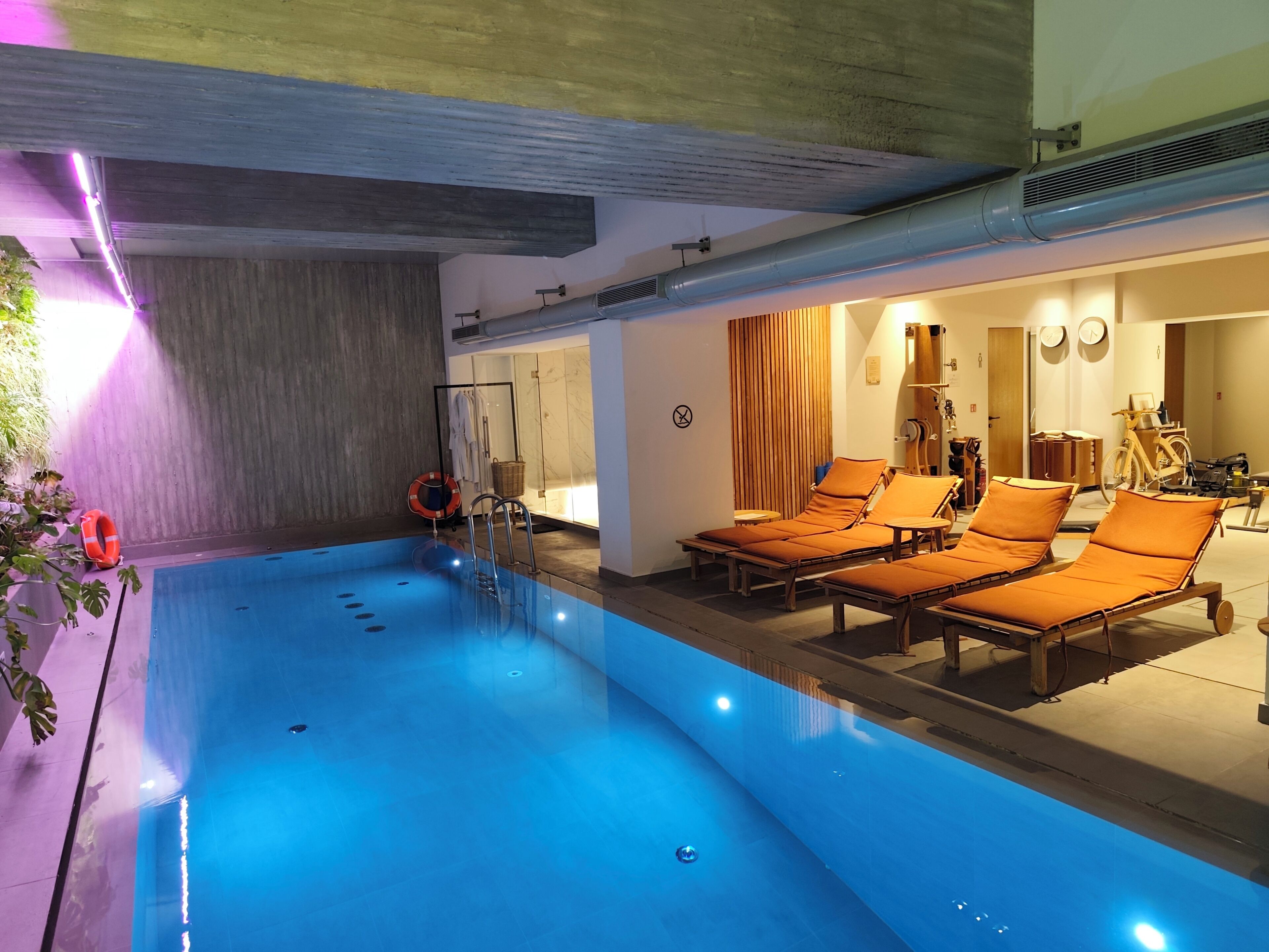 A swimming pool with lounge chairs and a wooden deck.