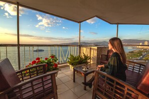 A balcony with a view of the sea and mountains, furnished with chairs and a table. - Izmir Palas Otel (Izmir)