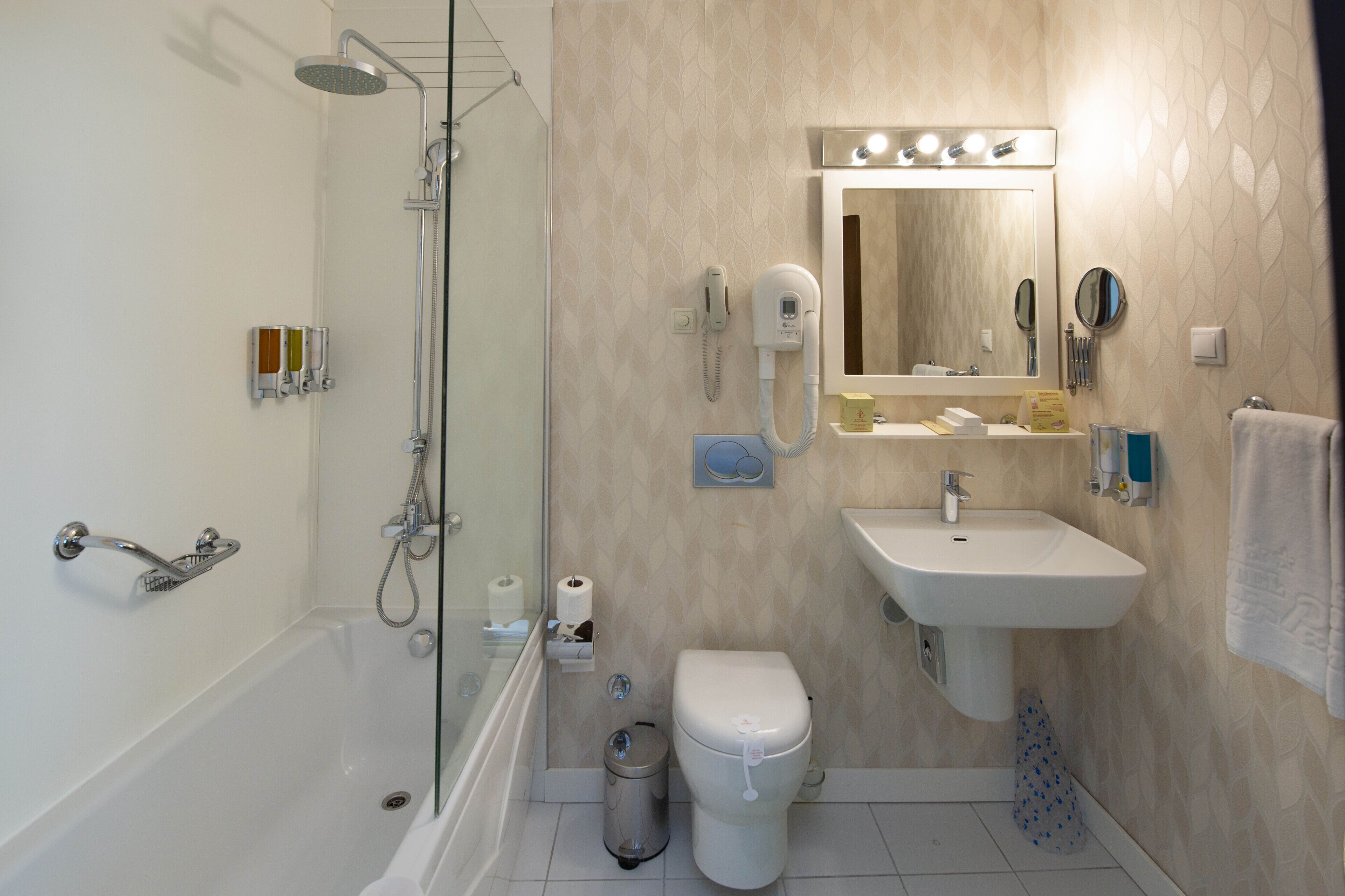 A modern bathroom with a glass-enclosed shower, a white sink, and a toilet.