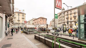 Una calle urbana con una parada de tranvía, edificios y una acera para peatones.