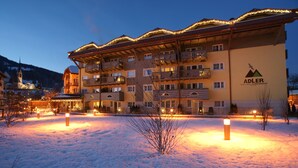 Een hotel met meerdere balkons en een met sneeuw bedekte grond.