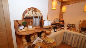 Un bufé de desayuno con tablas de madera, un letrero que dice "TRENTINO" y diferentes alimentos.