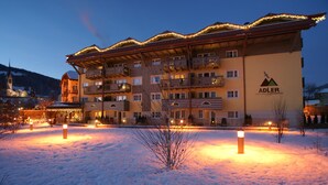 Un hotel de varios pisos con balcones y suelo cubierto de nieve.