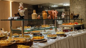 Un bufé con diversos alimentos y una figura de un chef.
