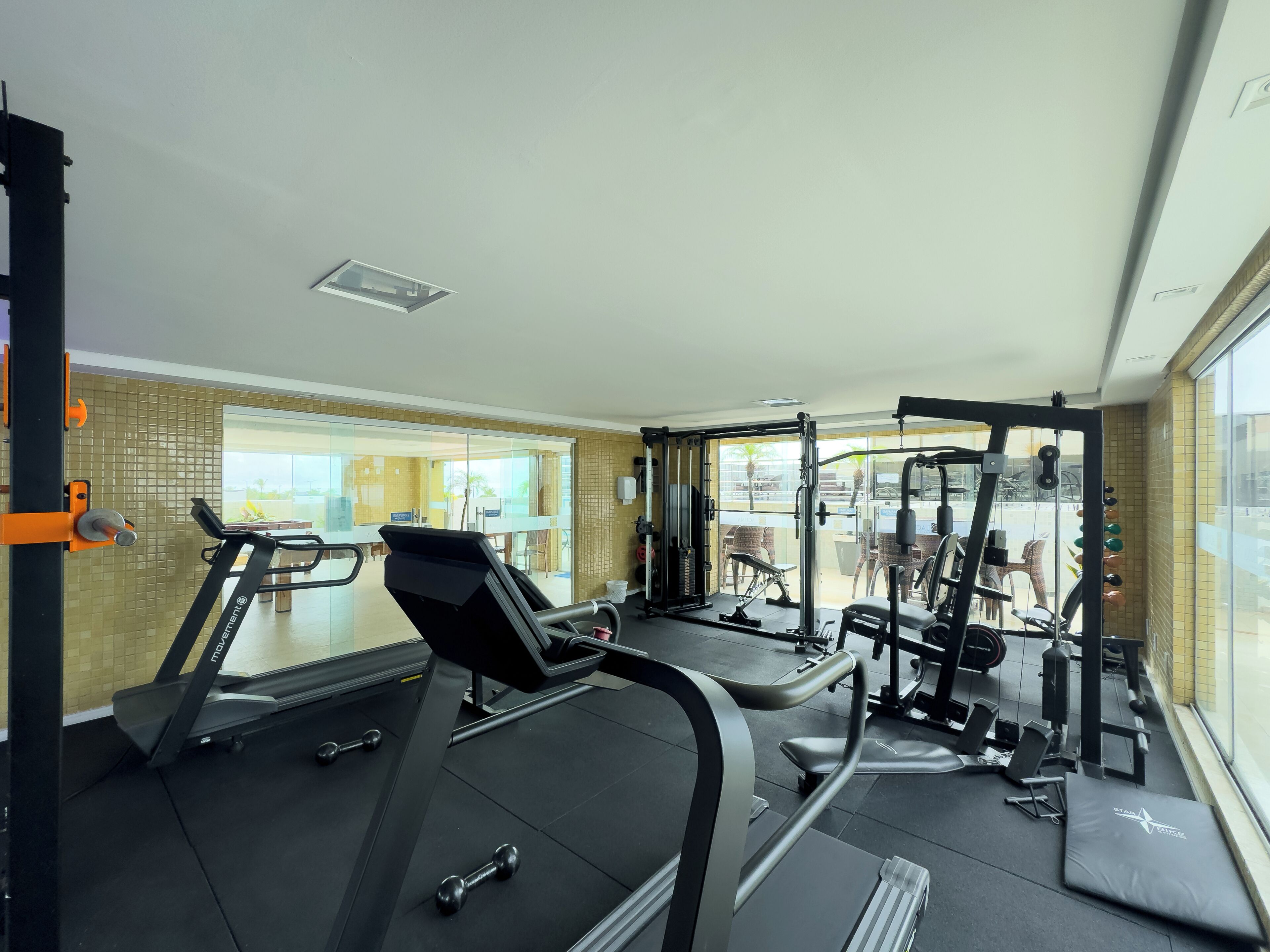 A gym with treadmills, dumbbells, and weight machines.