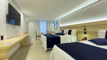 A hotel room with two beds, a desk, a chair, a TV, and a window with curtains.