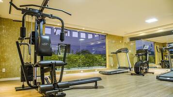 Une salle de sport équipée de matériel d’exercice, d’un tapis de course et d’un vélo d’appartement.