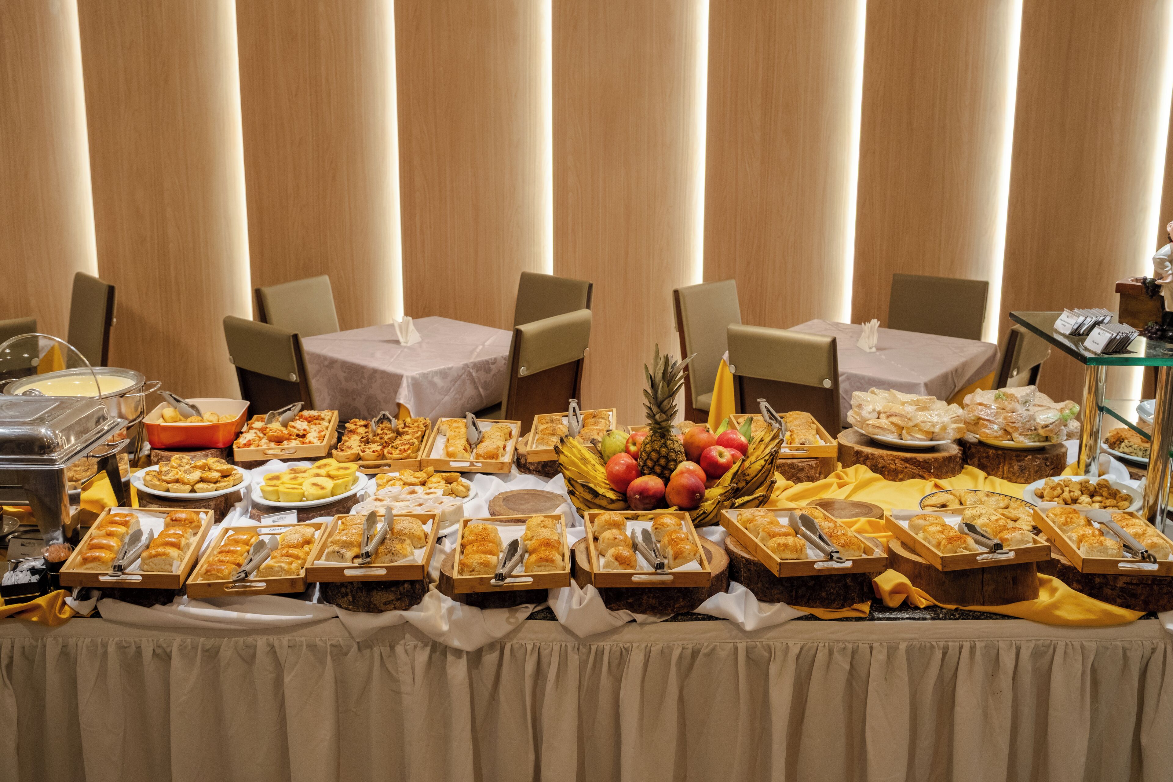 Un tavolo per buffet con diversi cibi e una ciotola di frutta.