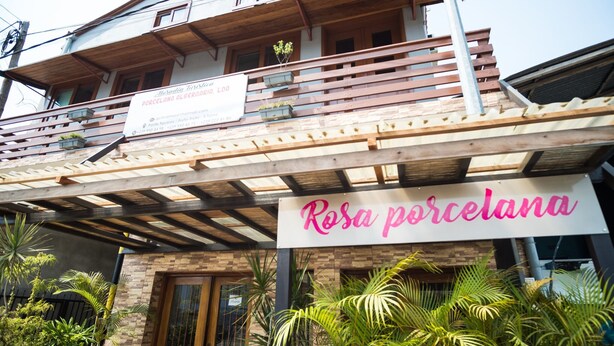 A building with a sign reading "Rosa porcelana" and another sign above it that says "Porcelana de Oregan LOA". - Porcelana Hotel (São Tomé)