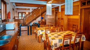 A wooden interior with a dining area, staircase, and kitchen. - Porcelana Hotel (São Tomé)