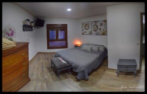 Cozy retreat with a comfortable bed, dresser, and wall-mounted TV.