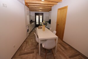Kitchen area with central island, dining table, and oven.