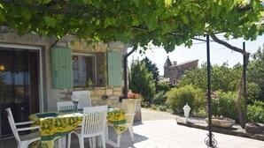 An outdoor patio with a table and chairs, covered by a green vine. - Relaxing Retreat in Saint-Pons (Saint Pons)