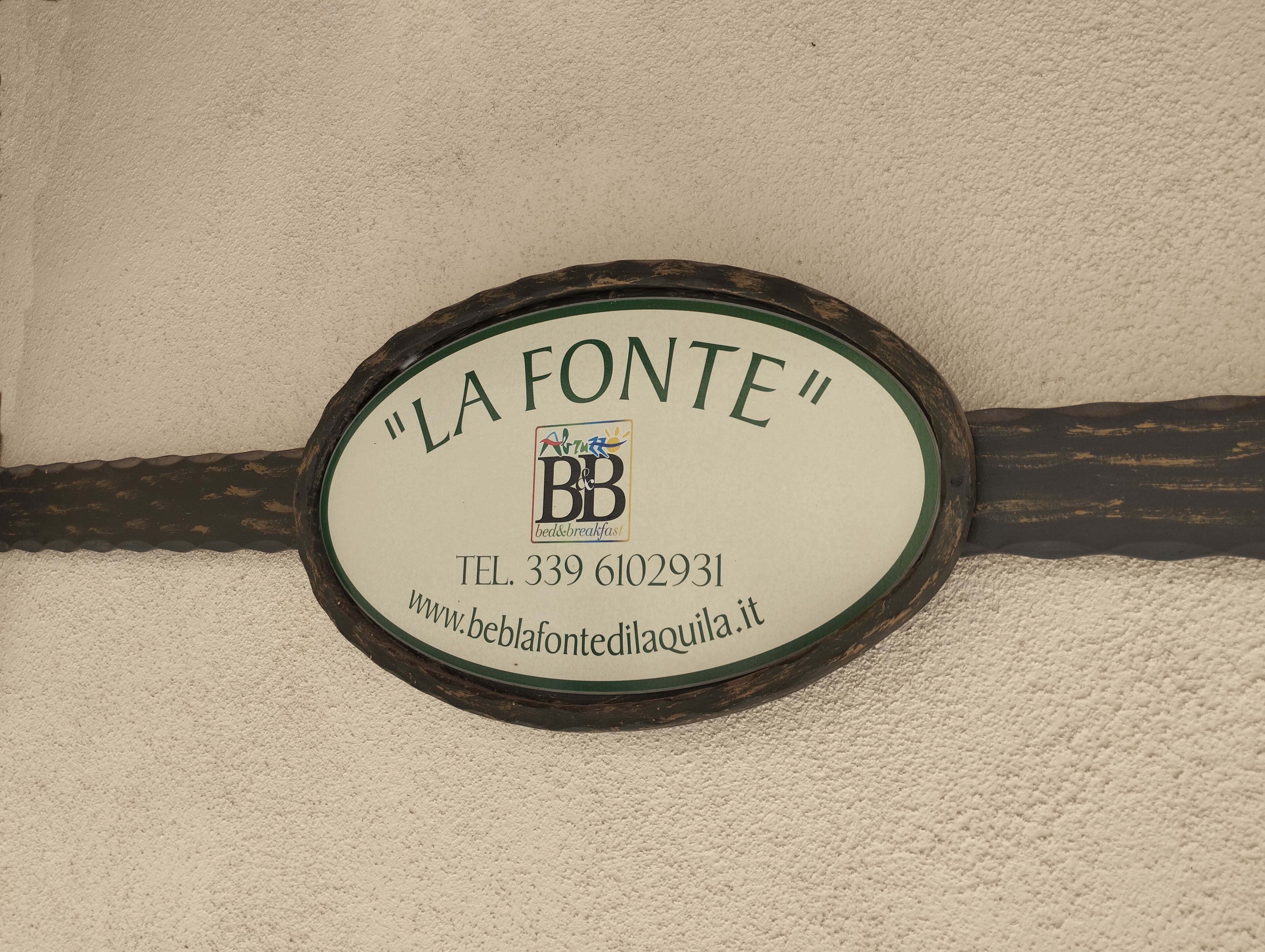 En skylt för bed & breakfast-stället ”LA FONTE” med kontaktuppgifter och webbadress.