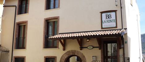 A two-story building with a sign reading "BB LA FONTE".