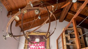 Un plafond en bois rustique avec des poutres apparentes et un lustre décoratif en métal.