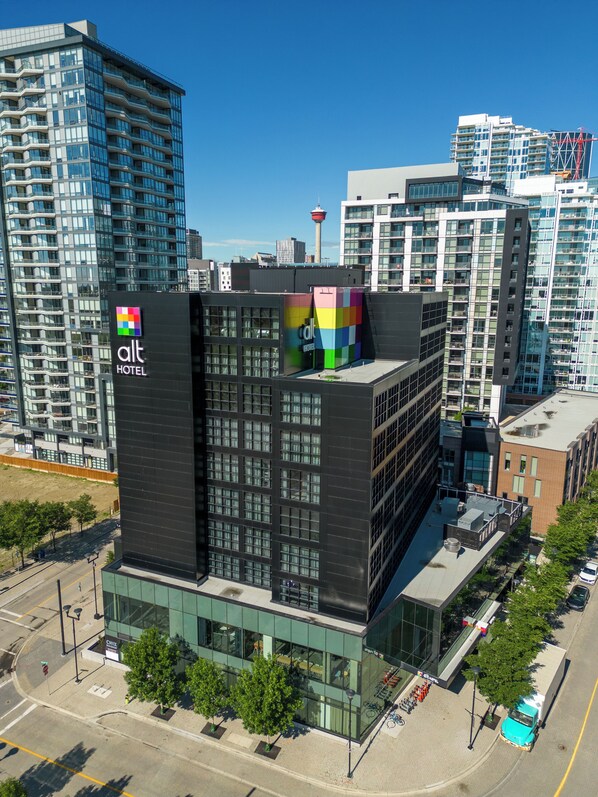 A modern hotel building with a prominent sign, large windows, and a flat roof. - Alt Hotel Calgary East Village (Calgary)
