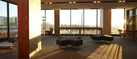A spacious office with large windows, modern furniture, and a view of the cityscape.