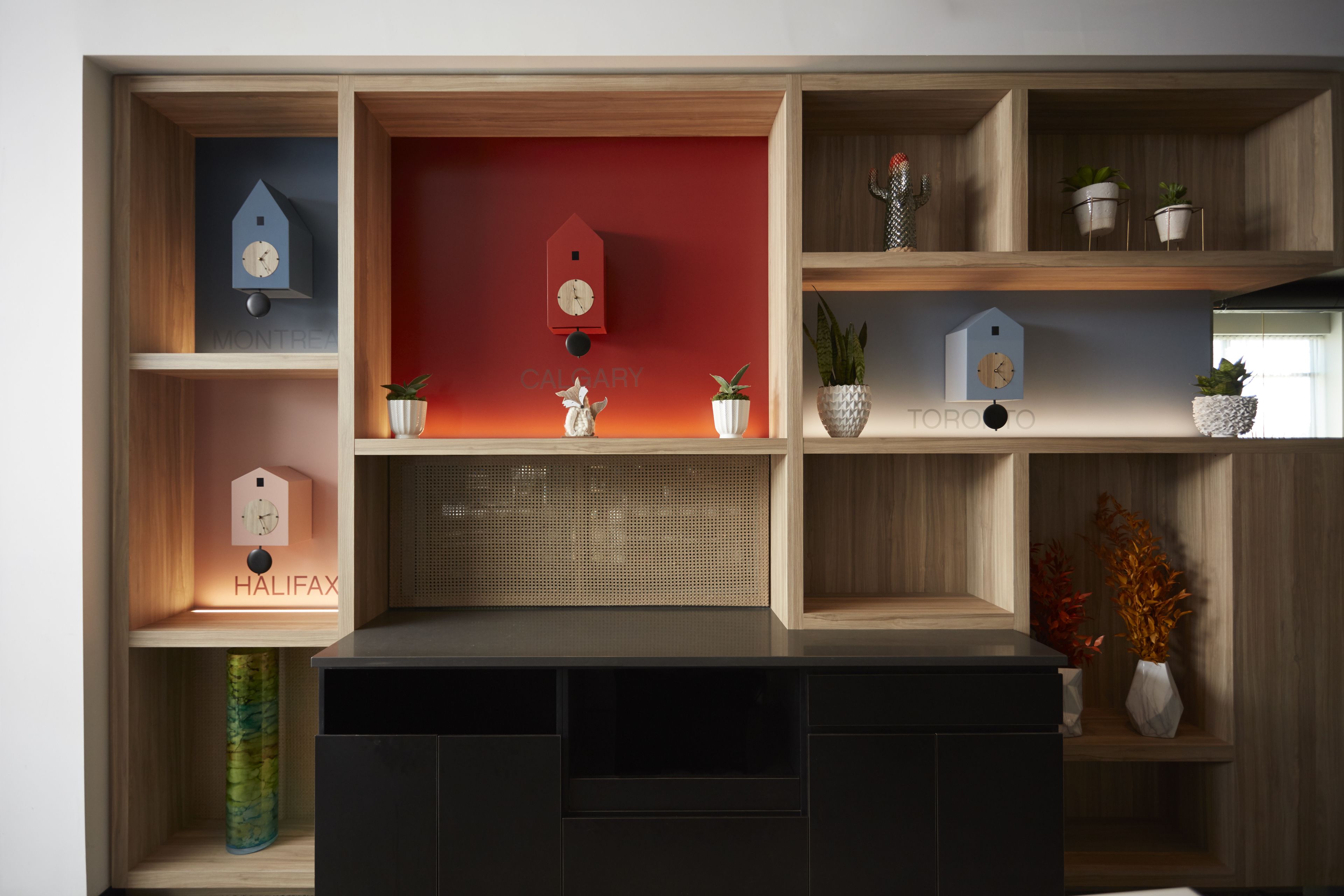 A wooden shelving unit with decorative items, including clocks and plants.