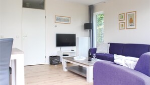 En moderne stue med fjernsyn, sofa og et lille bord.