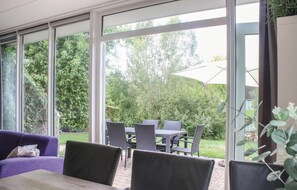 Relax in style with a dining table and comfortable seating under a spacious umbrella, surrounded by lush views.