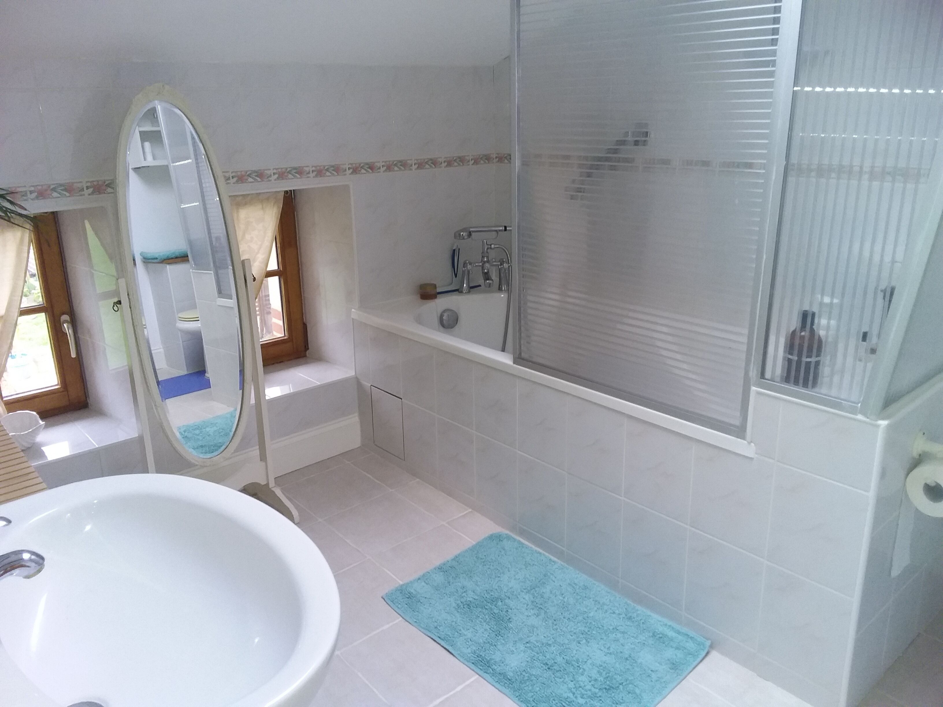 A bathroom with a bathtub, a sink, and a mirror.