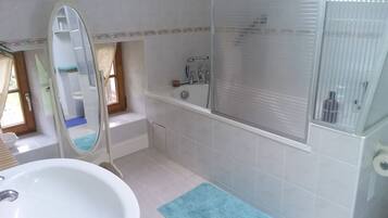 A bathroom with a bathtub, a sink, and a mirror.