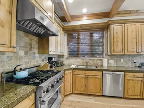 Enjoy cooking in this well-equipped kitchen with a central island, gas stove, oven, and dishwasher.