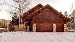 Cozy cabin with a large garage and stone chimney, perfect for a peaceful retreat.