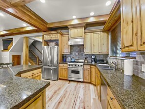 Enjoy cooking in this well-equipped kitchen with a stainless steel refrigerator, double ovens, and gas stove.