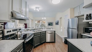 A modern kitchen with a central island, stainless steel appliances, and a view of a snowy landscape. - 62sl - Hot Tub - Wifi - Fireplace - Pets Ok 3 Bedroom Home by RedAwning (Deming)