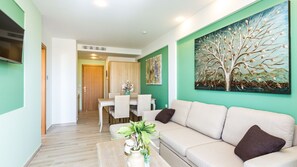 Suite – junior, balkong | Oppholdsområde | En 26-tommers Flatskjerm-TV med kabel-kanaler samt TV og bøker