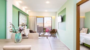 A modern hotel room with a sofa, a small table, a chair, and a bed.