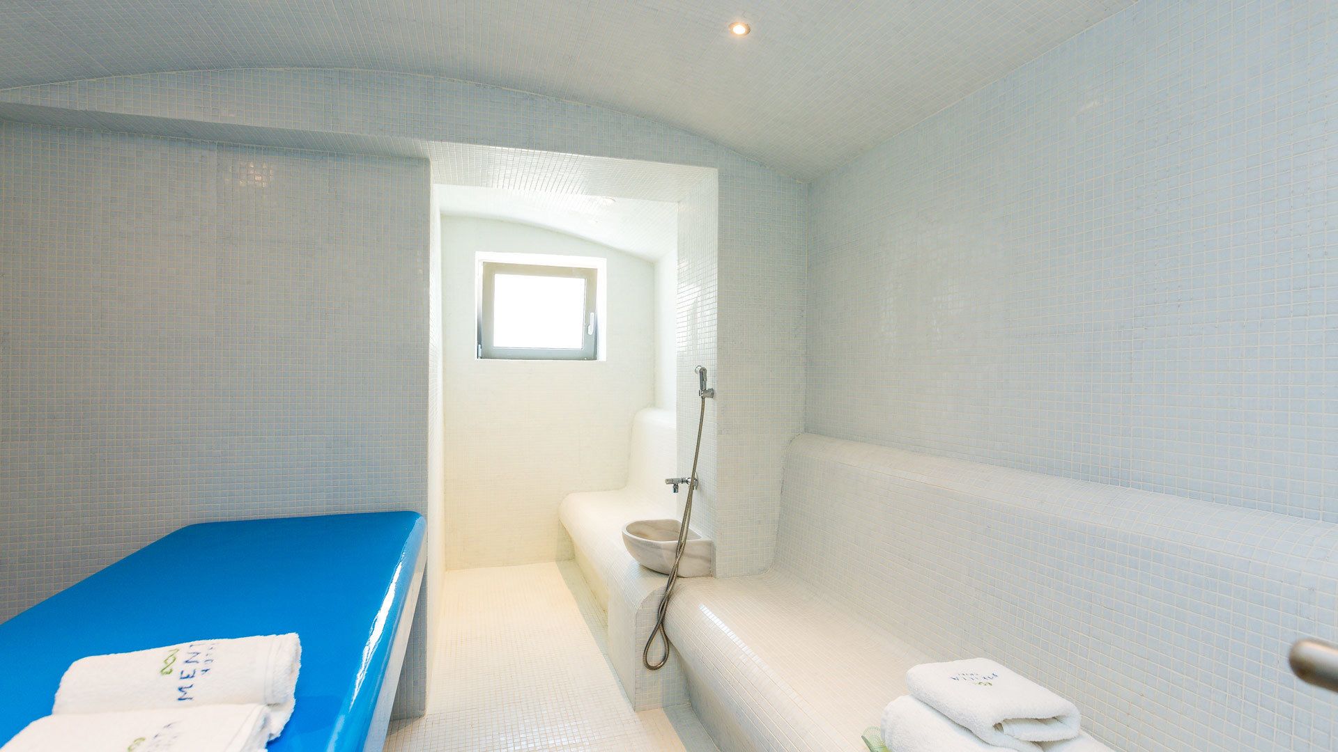 Une salle de bain moderne avec une baignoire bleue, un espace douche et des toilettes.