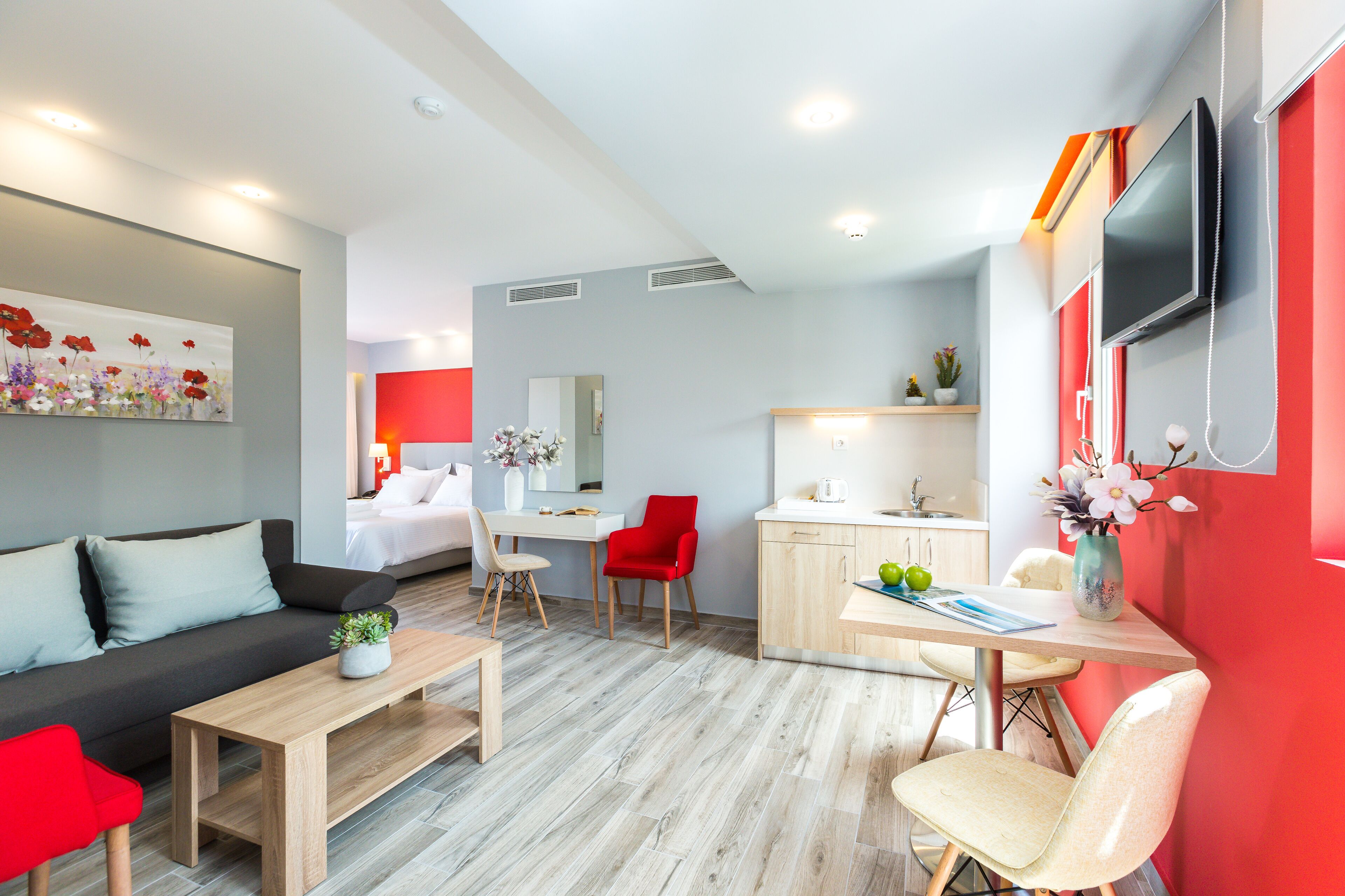 Um quarto de hotel moderno com área de estar, espaço para refeições e cozinha.