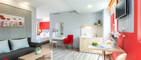 Um quarto de hotel moderno com área de estar, espaço para refeições e cozinha.