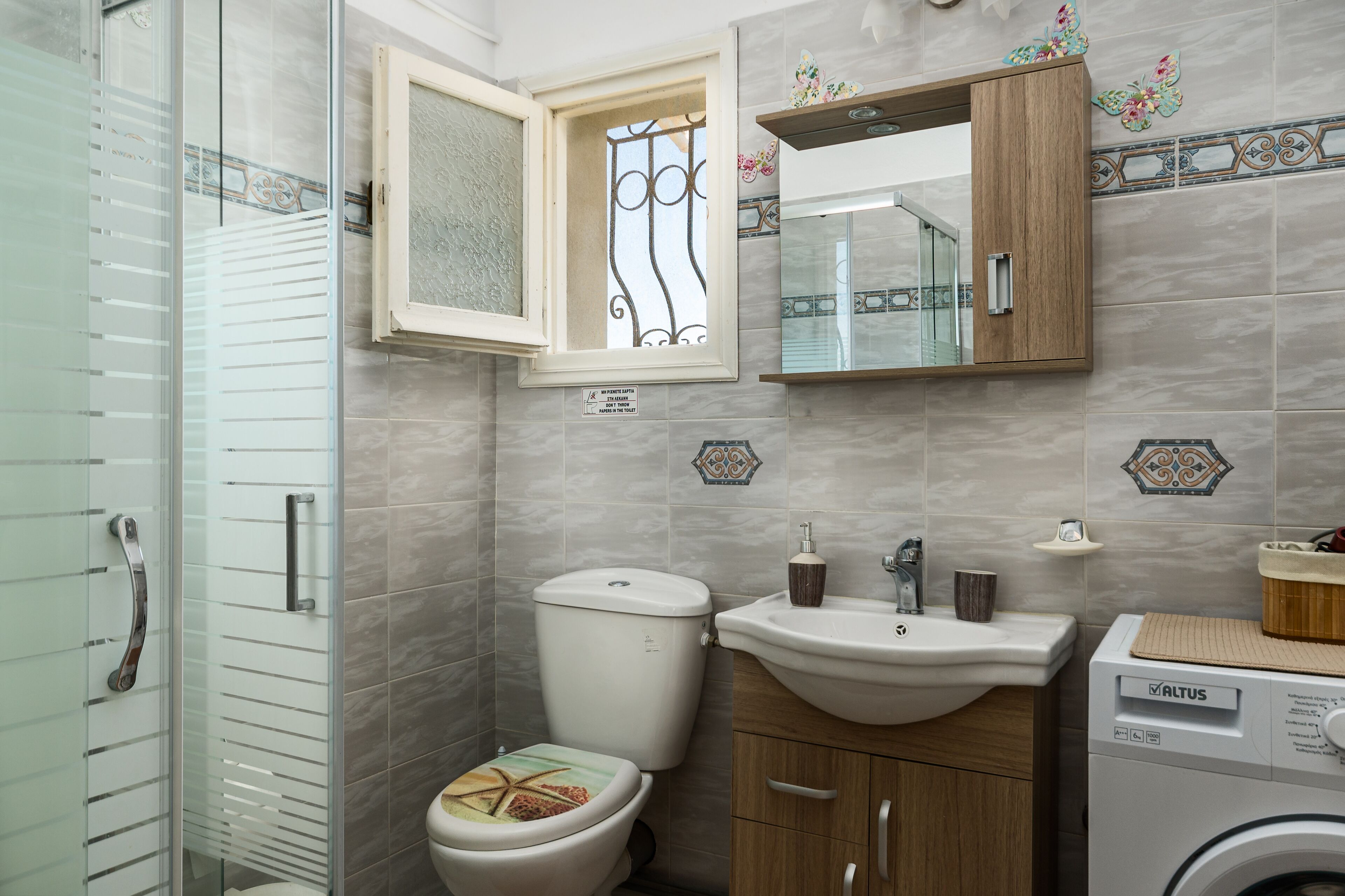 Une salle de bain équipée de toilettes, d’un lavabo et d’un lave-linge.