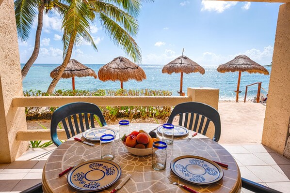 A table set for two with blue and white plates, a bowl of fruit, and a glass of water.