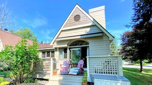 Ein kleines, eingeschossiges Haus mit Veranda, Garage und einer kleinen Terrassenfläche.