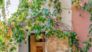 A cozy entrance with a stone floor, a welcome mat, and a sign reading "Electra House." - Loggos Panoramic Views Electra By Konnect (Paxos)