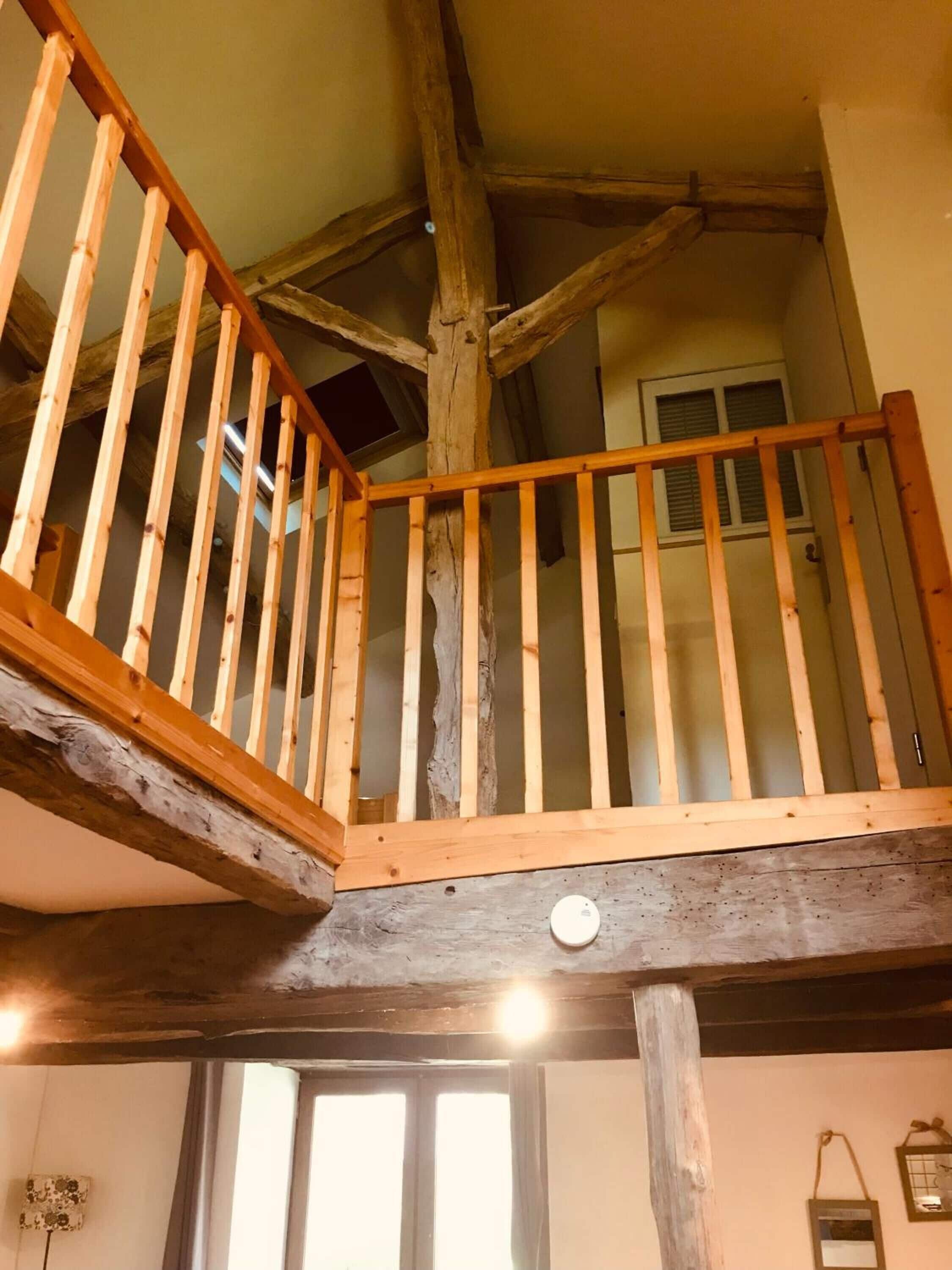 Una escalera de madera con barandilla que lleva a un piso superior.