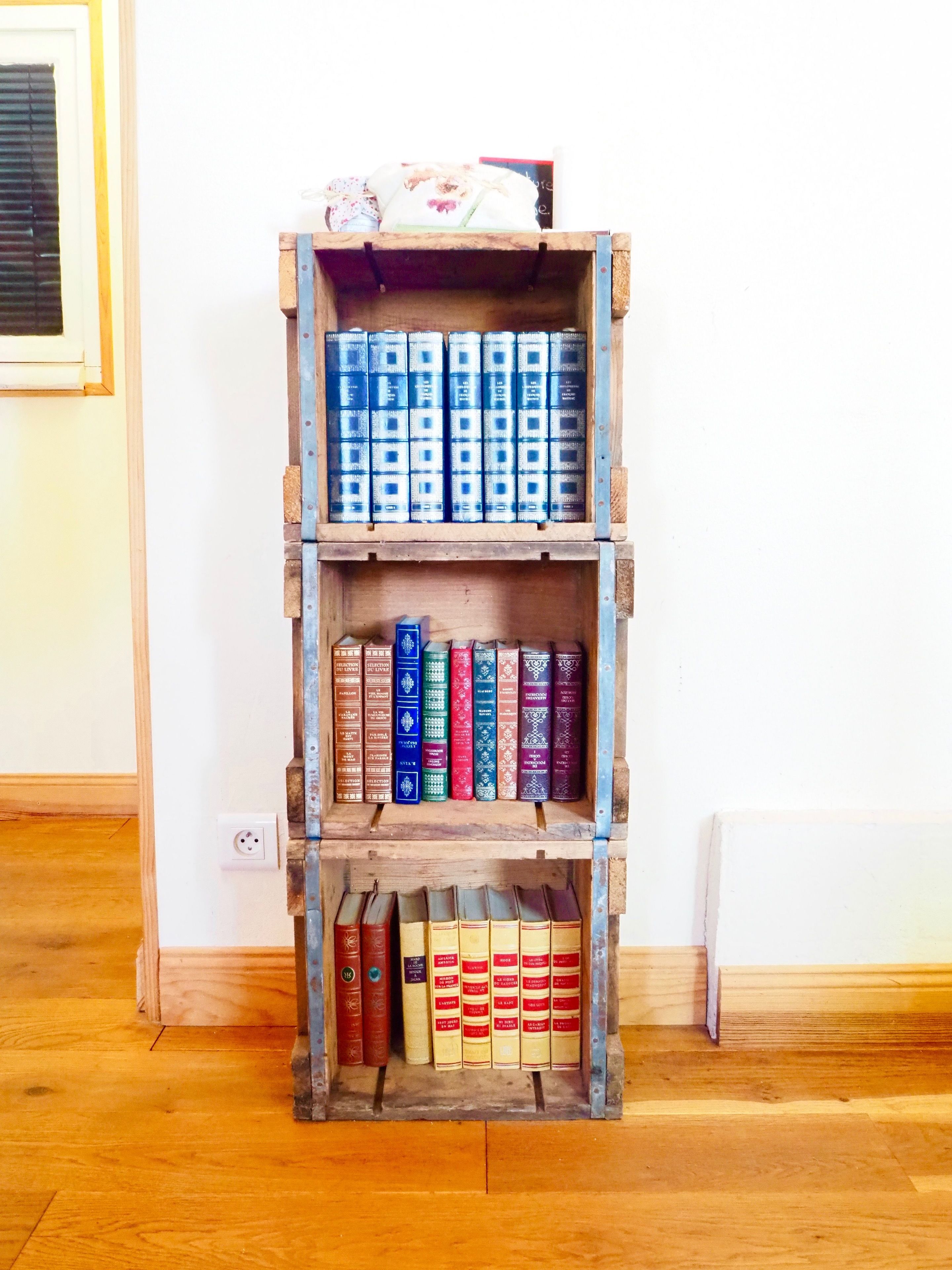 Una estantería de madera con varios estantes llenos de libros.