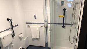 A bathroom with a toilet, a glass-enclosed shower, and a towel rack.