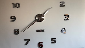 A wall clock with a minimalist design, featuring numbers and the word "TIME" in the center.